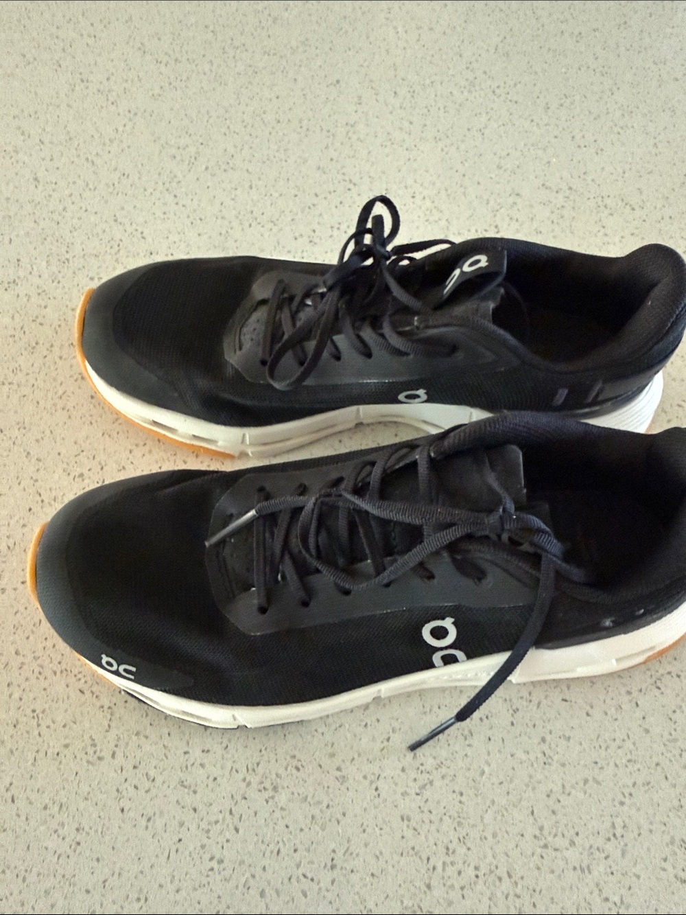 On Running Black Athletic Shoes with White Midsole and Orange Outsole Accents